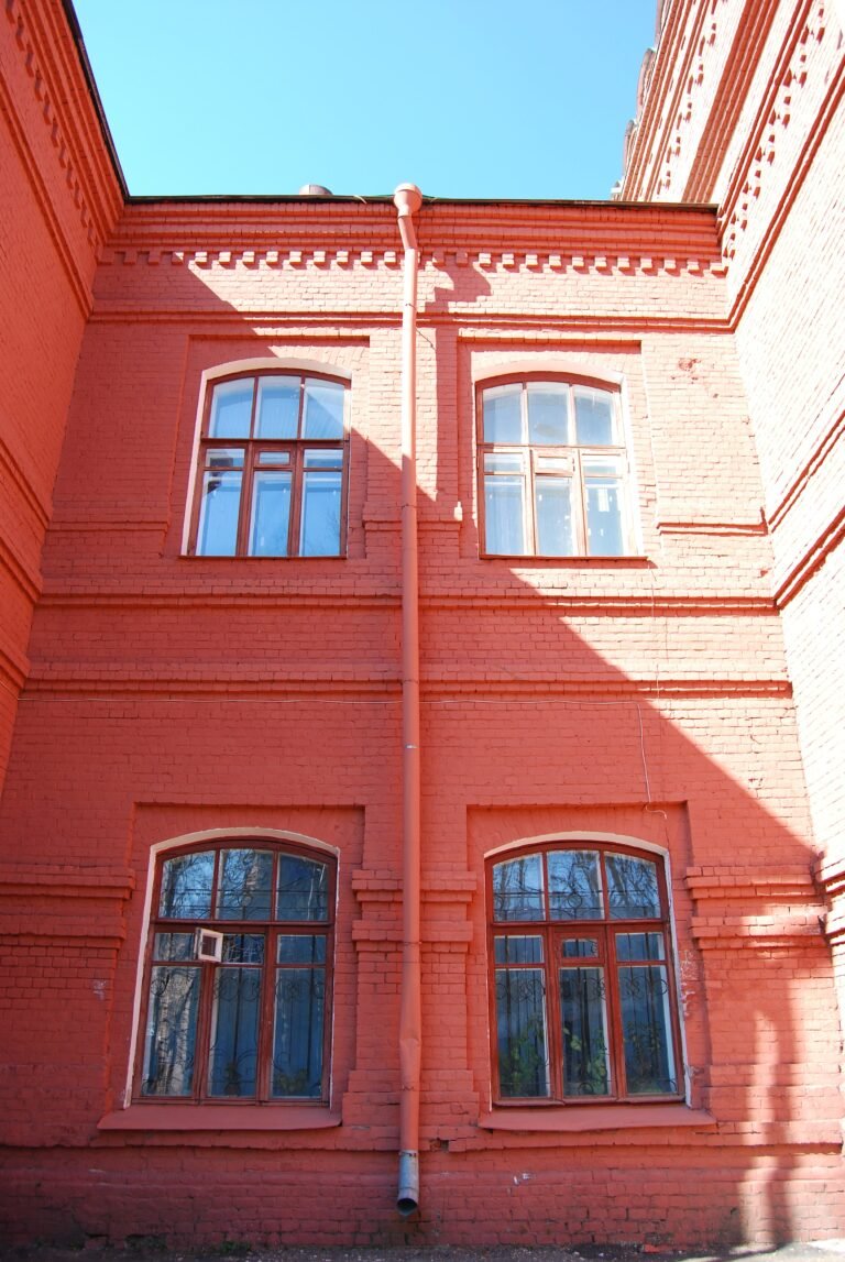 a red brick building with two windows and a clock